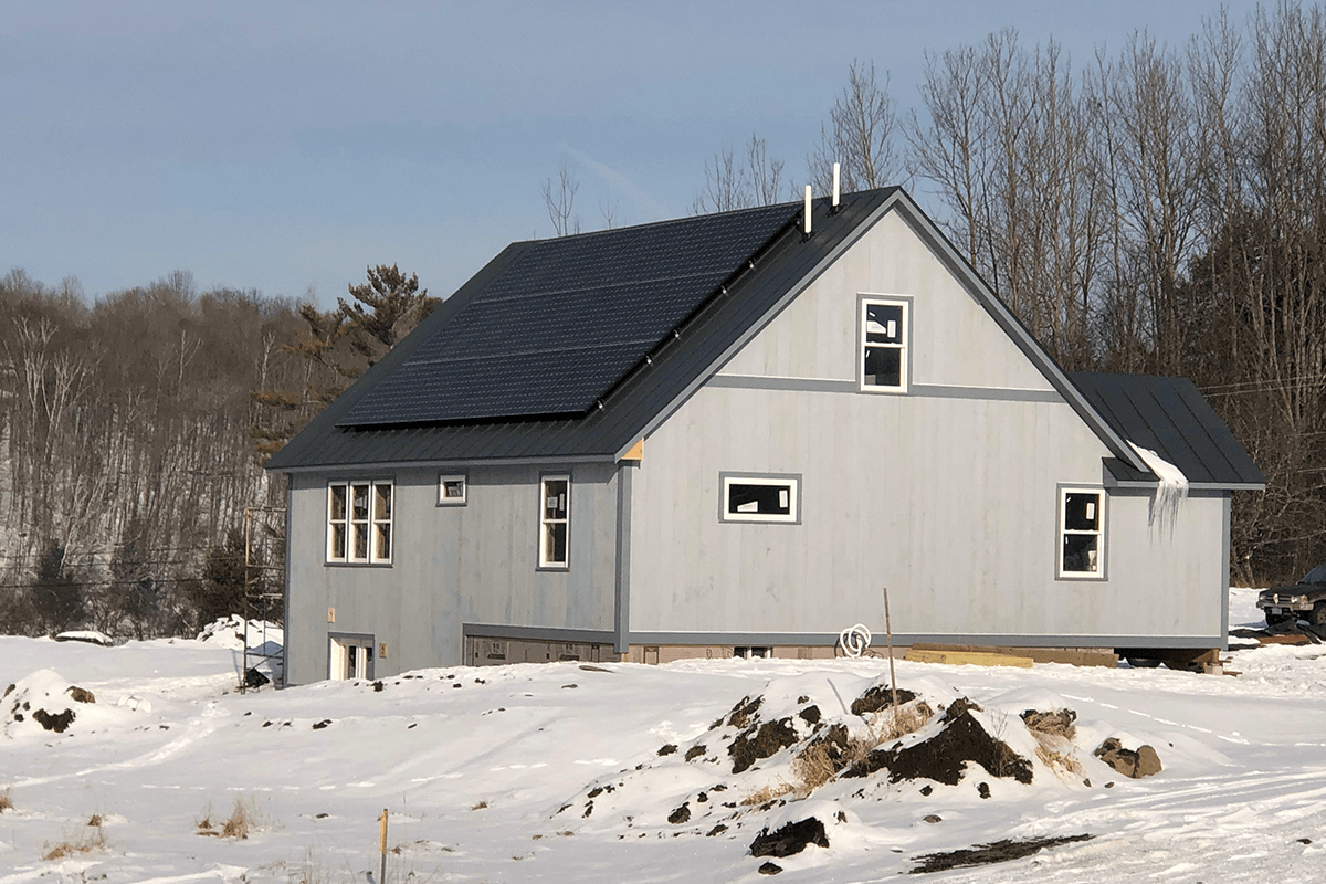 Image of nearly finished home with solar panels built by Free Range Builders